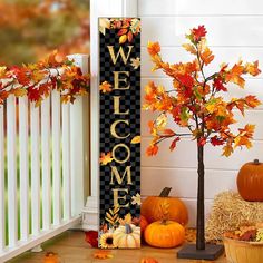 a welcome sign with fall leaves and pumpkins