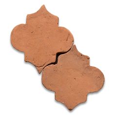 two pieces of red clay sitting next to each other on a white surface with no one in it