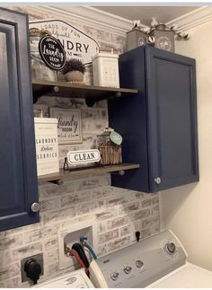 a washer and dryer in a small room with blue cabinets on the wall