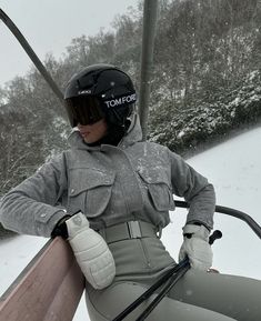 a woman sitting on top of a ski lift