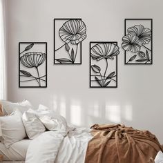 three black and white flowers are hanging on the wall