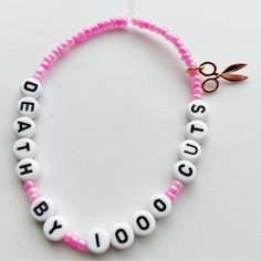 a pink and white beaded bracelet with the words dead tooth written on it's side