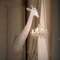 a giraffe figurine hanging from a chandelier in a room