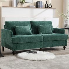 a green couch sitting on top of a white rug