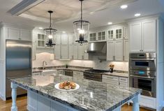 a large kitchen with marble counter tops and stainless steel appliances