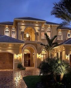 a very nice looking house with lots of lights on it's front doors and windows