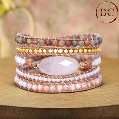 Elevate your boho jewelry collection with this exclusive women's rose quartz charm 5-layer beads wrap bracelet. This exquisite piece features multiple layers of high-quality leather, meticulously adorned with delicate rose quartz beads and charms, creating a stunning blend of natural beauty and bohemian flair. The bracelet showcases five layers of leather, each intricately wrapped with smooth rose quartz beads. Known for their gentle pink hue and calming energy, the rose quartz stones add a touch of elegance and serenity to the bracelet. The addition of charming rose quartz accents or detailed charms further enhances the bracelet's overall design, infusing it with a unique and sophisticated appeal. Handcrafted with precision, this multilayered bracelet wraps comfortably around the wrist, o Bohemian Hand Wrapped Rose Quartz Bracelets, Bohemian Beaded Bracelets With Rose Quartz, Bohemian Rose Quartz Beaded Bracelets With Adjustable Fit, Bohemian Rose Quartz Adjustable Beaded Bracelets, Bohemian Adjustable Rose Quartz Beaded Bracelets, Bohemian Hand-wrapped Rose Quartz Beaded Bracelets, Bohemian Hand Wrapped Rose Quartz Beaded Bracelets, Beadwork Bracelet, Beaded Wrap Bracelets