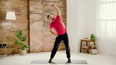 a man standing on a yoga mat in front of a brick wall