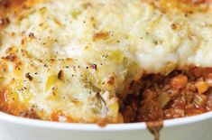 a casserole dish with meat, cheese and vegetables is shown in a white bowl