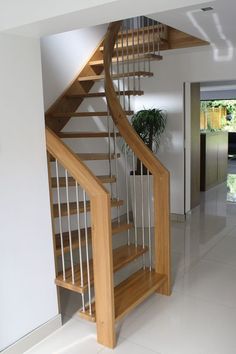 there is a wooden stair case in the room with white tile flooring and walls