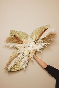 a woman is holding up a paper flower with feathers on it's back and an umbrella shaped like a bird