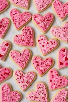 valentine's day cookies with sprinkles and pink frosting in the shape of hearts