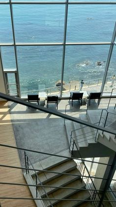 stairs leading up to the top floor of a building with glass walls and ocean view