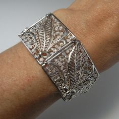 Here is an exceptional Art Nouveau completely handmade silver filigree bracelet circa 1890. The workmanship here is reminiscent of 18th century filigree in the quality and intricacy of this amazing piece. Each panel is entirely made by hand with silver wire twisted and wound into a fern and frond design each bouquet tied with a feminine bow. Amazingly each panel is not flat but the silver lace design is raised in relief with the central fern frond sitting higher to the rest of the panel. When th Elegant Luxury Antique Silver Cuff Bracelet, Victorian Cuff Bracelet With Intricate Design For Ceremonial, Victorian Cuff Bracelet With Intricate Design For Ceremonial Occasions, Victorian Style Ceremonial Cuff Bracelet With Intricate Design, Victorian Bangle With Intricate Design For Ceremonial Occasions, Elegant Engraved Ceremonial Cuff Bracelet, Elegant Ceremonial Engraved Cuff Bracelet, Elegant Engraved Cuff Bracelet For Ceremonial Occasions, Antique Cuff Bracelet With Intricate Design For Formal Occasions