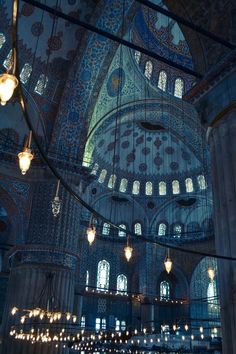 the inside of an ornate building with chandeliers hanging from it's ceiling