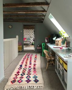 a room with a rug, desk and chair in it