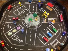 toy cars and trucks are arranged in the shape of a circle on a chalkboard