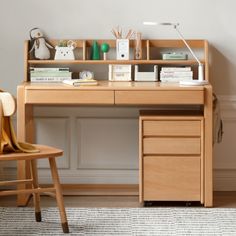 a wooden desk with a chair next to it and shelves on the wall behind it