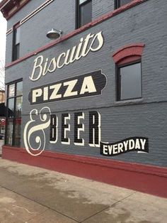 the sign for biscuits pizza and beer is painted on the side of a building