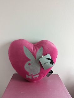 a pink heart shaped pillow sitting on top of a table