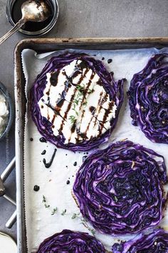 an overhead view of grilled cabbage on a baking sheet with other food items and utensils