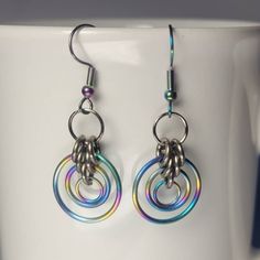 Handmade chainmail multicoloured rainbow earrings. Hand woven one ring at a time, this jewelry is sure to turn heads! This set is made of Rainbow  anodized titainium rings silver titanium rings and rainbow stainless steel hooks. These are ultra lightweight, do not tarnish and are comfortable to wear. I use high quality rings and the colours will not rub off on your skin. This product is made to order so it may take 10- 14 business days to ship Leo Jewelry, Rainbow Circle, Quality Rings, Titanium Jewelry, Rings Silver, Rainbow Earrings, Titanium Rings, Hypoallergenic Earrings, One Ring