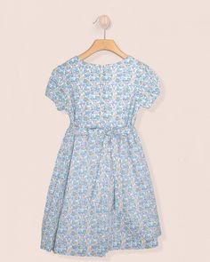 Demoiselle's Beauty Lies in Her Understated Elegance. Designed in a beautiful liberty floral print, this dress features a gathered smocked bodice along the chest for a more casual look. It is fully lined with short puff sleeves and matching self-tie sash with elegant buttons for a sophisticated touch. 100% Liberty of London Cotton. Fully Lined in Cotton. Delicate Machine Wash Cold, Flat Dry, Cool Iron, Dry Clean Liberty Floral, Liberty Of London, Understated Elegance, Blue Dress, Puff Sleeves, Blue Dresses, Puff Sleeve, Casual Looks, Bodice