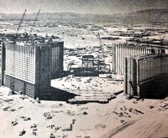 an aerial view of some buildings in the middle of a large city with construction cranes