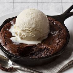 a chocolate cake with ice cream in a cast iron skillet on a white plate