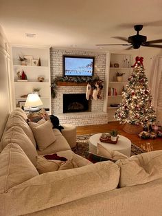 a living room filled with furniture and a christmas tree in front of a flat screen tv