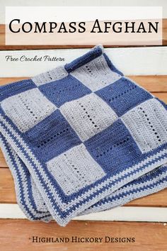 a blue and white crocheted afghan sitting on top of a wooden table next to a