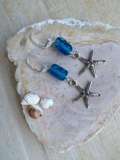 These ocean inspired earrings have a starfish charm that has great texture and detail, the last photo shows both sides of the charm. They are made with tube shaped glass beads that are the colors of ocean water, blue with spots of mint green. The earrings are 2-3/8 inches long; the starfish charm is 3/4 inch in height and 3/4 inch in width. I have more starfish charms to make a custom pair of earrings just for you! For other ocean inspired earrings please see www.etsy.com/shop/BeachDaisyJewelry? Blue Star Jewelry For Vacation, Blue Star Shaped Jewelry For Vacation, Blue Starfish Charm Jewelry For The Beach, Blue Starfish Charm Jewelry For Summer, Ocean-inspired Starfish Charm Earrings, Summer Blue Starfish Charm Jewelry, Blue Summer Jewelry With Starfish Charm, Blue Starfish Jewelry For Beach, Nickel-free Starfish Earrings Ocean-inspired