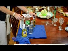 a woman is setting the table with bottles of alcohol