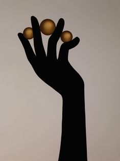 a person's hand holding three balls in the air