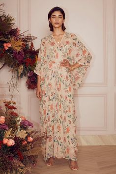 Beige floral print kaftan with scallop detail on the hems and tie up at the waist. Comes with inner.
Component: 2
Pattern: Print
Type Of Work: Floral Print
Neckline: V neck
Sleeve Type: Flared
Fabric: Kaftan: Georgette and Inner: Mulmul
Color: Beige
Other Details: 
Lace trim on the neckline
Occasion: Resort
Disclaimer: Product colour may slightly vary due to photographic lighting sources and  there can be slight difference in motif print placement due to running print fabric. - Aza Fashions Kaftan Pattern, Ridhi Mehra, Big Floral, Print Placement, Photographic Lighting, Fashion Wear, Print Fabric, Aza Fashion, Sleeve Type