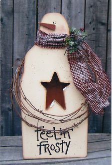 a wooden snowman with a star on it's head and barbed wire around its neck