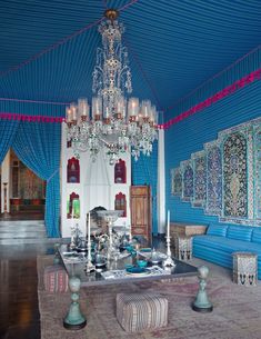 an elaborately decorated room with chandelier and blue walls