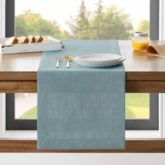 a table with a plate and silverware on it next to a box of bread