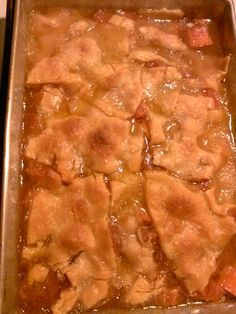 a casserole dish with meat and vegetables in it sitting on a stove top