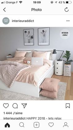 a white bed sitting on top of a wooden floor next to two pictures above it