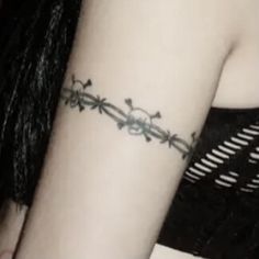 a woman's arm with a barbed wire tattoo on her left arm and the word love written in black ink