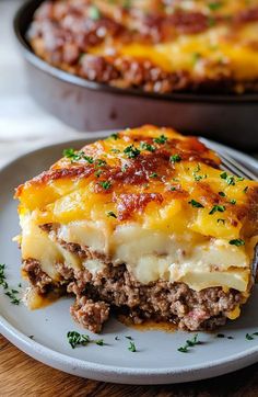 a piece of lasagna on a plate next to a casserole dish