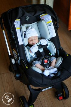 a baby in a car seat on the floor