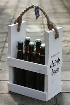 a wooden crate with six beer bottles in it and a rope hanging from the handle