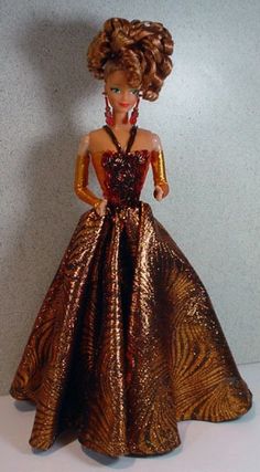 the doll is wearing a gold dress with red and black details on it's chest