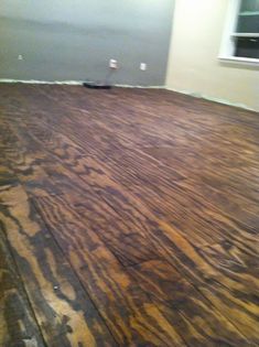 an empty room with wood flooring in the process of being painted and sealed off