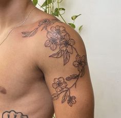 a man with a flower tattoo on his left arm and chest is looking at the camera