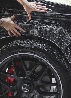 a man washing his car wheel with soap