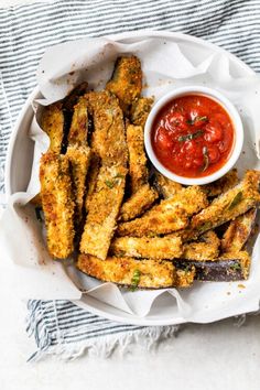 fried fish sticks with ketchup in a white bowl