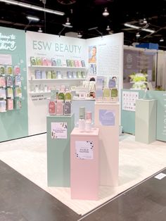 a display in the middle of a room with bottles on it and signs for beauty products